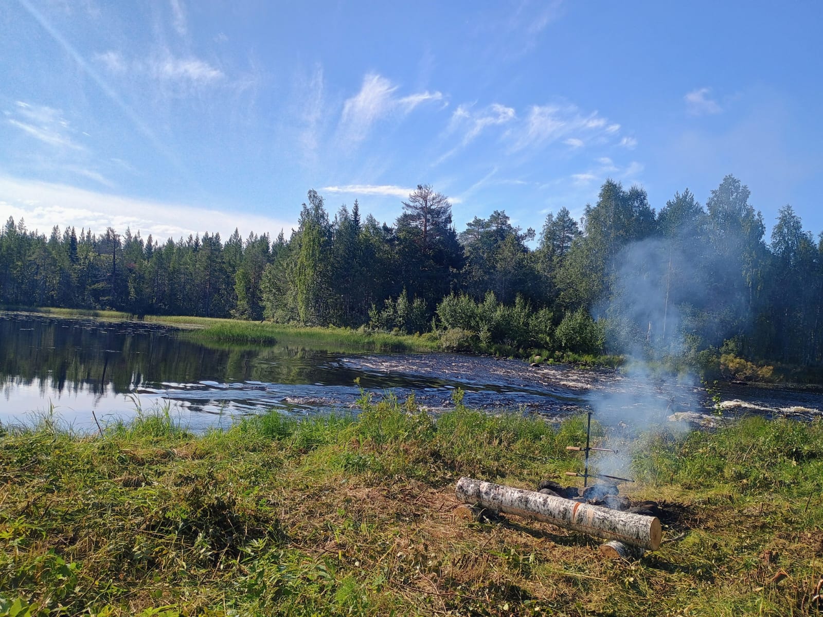 Nuotiopaikka kosken rannalla kesäpäivänä