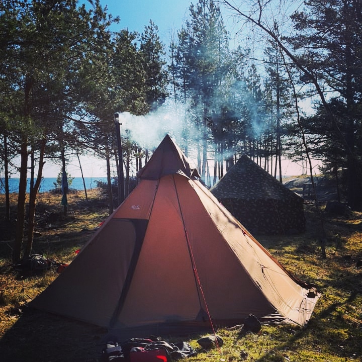 Kotateltta järven rannalla kesäyössä