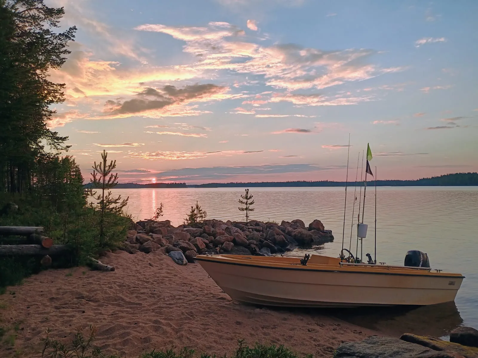 Auringonlasku järvellä ja vene rannalla