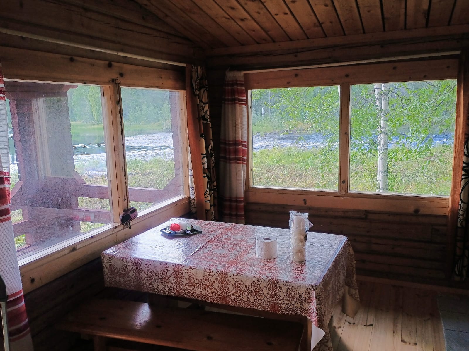 Tuvan pöytä ja penkit ikkunoiden äärellä