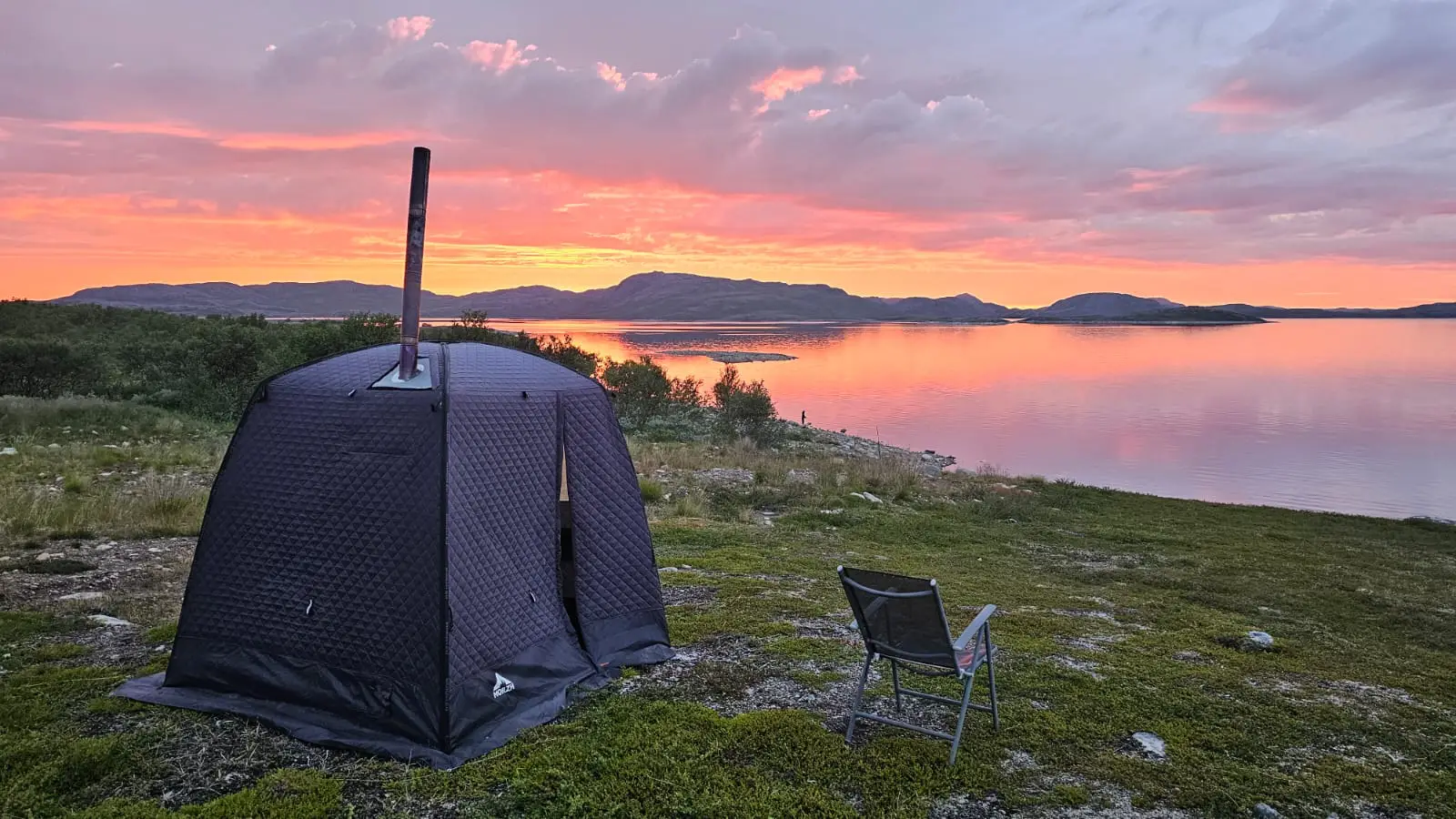 Telttasauna järven rannalla auringonlaskussa